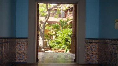 4k video of camera moving thorugh big doorway in patio with garden and fountain inside beautiful old palace in spanish style
