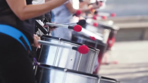 Closeup 4k video of group of street musicians playing on drums. Culture festival or carnival on city street — ストック動画