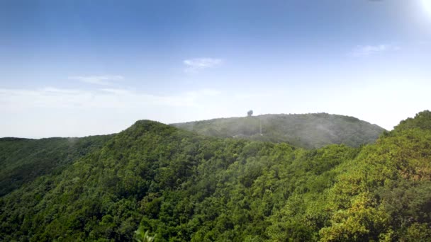 4k vídeo de nuvens voando passado altas torres de comunicação de rádio de metal em picos de montanha na selva — Vídeo de Stock