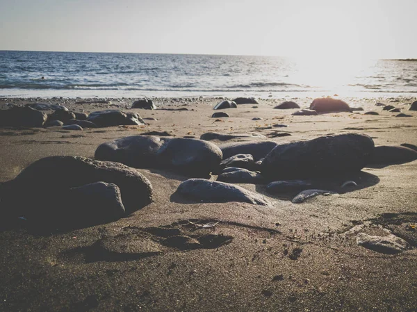 Imagem tonificada do pôr do sol na praia do oceano coberta de seixos — Fotografia de Stock