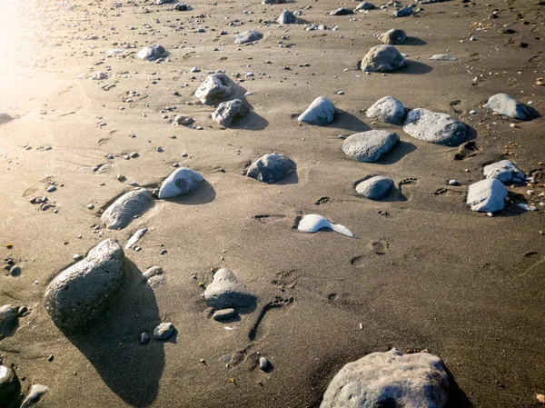Krásná fotografie západu slunce na černé sopečné pláži pokryté skálami a kameny — Stock fotografie