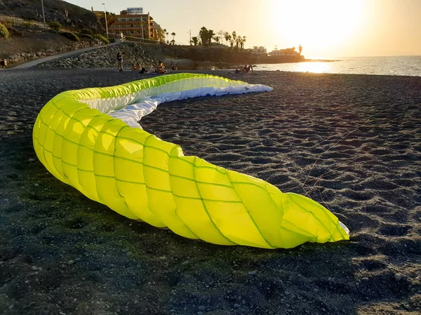 Bela imagem de parapente paraquedas deitado na praia do oceano ao pôr do sol — Fotografia de Stock