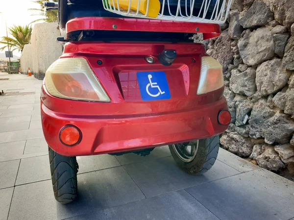 Fauteuil roulant électrique rouge pour personnes handicapées stationnées sur la route — Photo