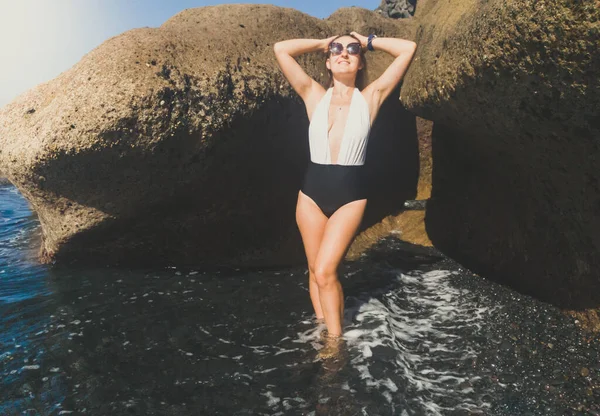 Imagen tonificada de una hermosa joven sonriente disfrutando del sol y el océano en la playa — Foto de Stock