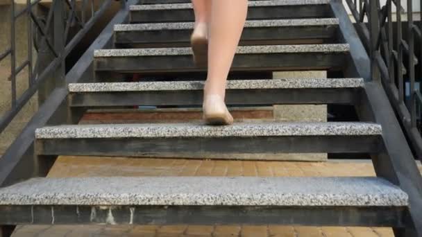 Primer plano 4k video de la cámara siguiendo los pies femeninos en pisos de ballet y pantimedias subiendo las escaleras de piedra en la calle de la ciudad — Vídeo de stock