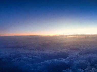 Karanlık gece gökyüzünde güneşin bulutların üzerinde doğuşunun inanılmaz görüntüsü.