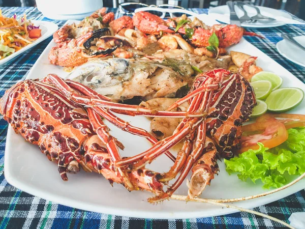 Foto di gamberi, langoustini, aragoste e calamari in primo piano sul grande piatto al ristorante di pesce — Foto Stock