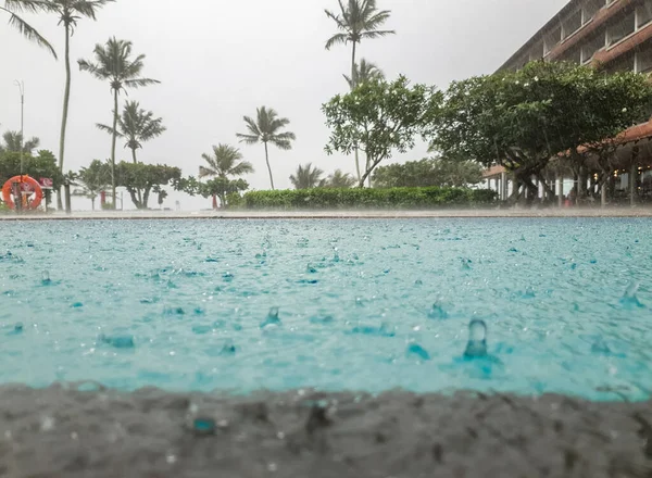 Close-up foto van hevige tropische regen op het tropische eiland. Waterdruppels vallen in het zwembad — Stockfoto