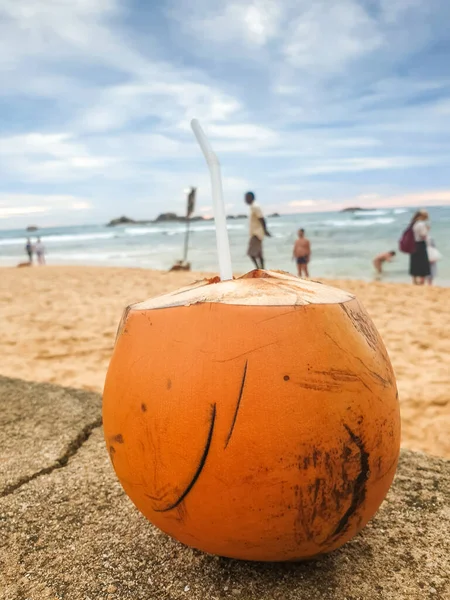 Closeup image of yellow coconut with drinking straw on the ocean beach — Stock Photo, Image