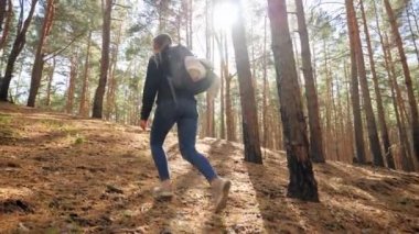 4k slow motion video of young female hiker or tourist walking up the hill in forest while hiking