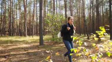 4k footage of happy smiling woman smiling while hiking in the forest on sunny day