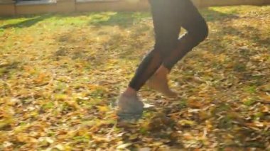 4k video of young woman with excess weight doing fitness exercise and running at beautiful autumn park
