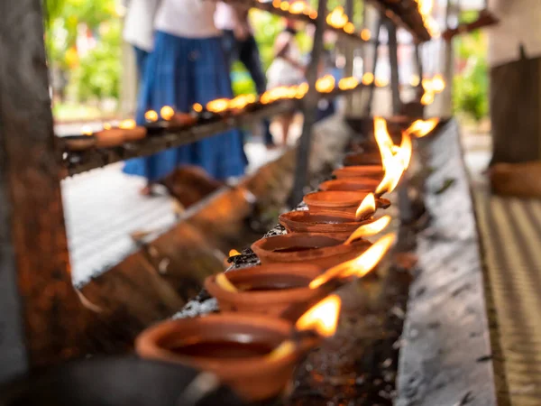 Foto de cerca de las últimas horas de aceite quemándose en el santuario en el templo budista — Foto de Stock