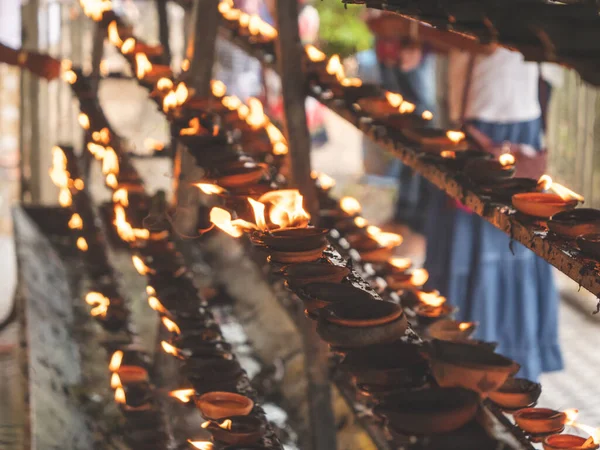 Imagen tonificada en primer plano de largas filas de linternas de aceite ardiendo y lámparas en el templo budista o hindú — Foto de Stock