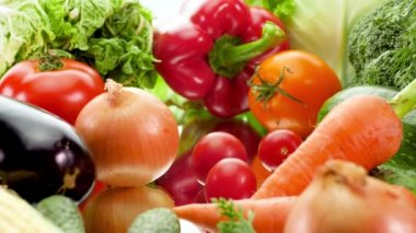 4k dolly video of big assortment of fresh seasonal vegetables against white background. Concept of healthy nutrition and organic food. Perfect shot for vegetarian or vegan