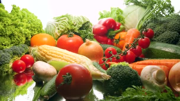 4k головокружительное видео большого количества овощей, лежащих на зеркале на белом фоне. Концепция здорового питания и органических продуктов питания. Идеальный снимок для вегетарианца или вегана — стоковое видео
