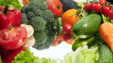 Closeup 4k video of vegetables slices and water droplets falling on mirror surface. Concept of healthy nutrition and organic food. Perfect background for vegetarian or vegan. Cooking salad