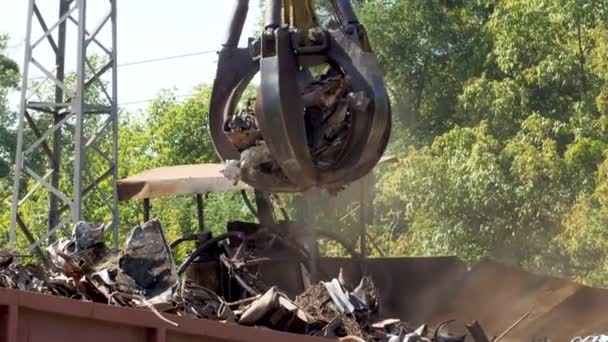 4k video of hydraulic claw manipulator carrrying old metal scrap and loading it in high pressure machine. Concept of metal recycling — Stockvideo