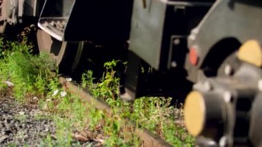 Closeup 4k video of heavy cargo train wheels riding on railroad. Concept of transportation and cargo using railways