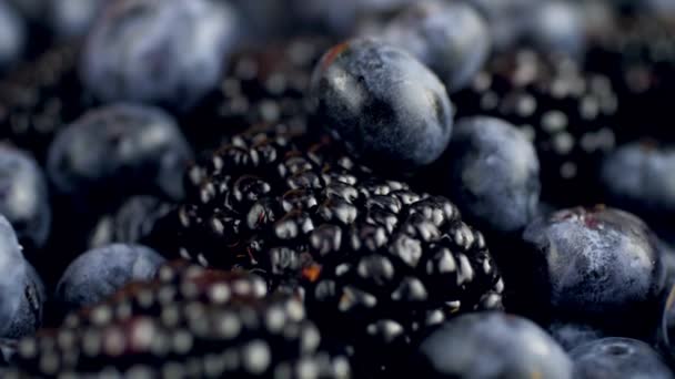 4k dolly video of lots of blackberries and blueberries lying on desk. Perfect abstract background for organic food and healthy nutrition. — Stock Video