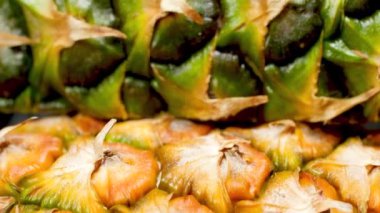 Kameranın taze ananas derisinin üzerinden geçişini gösteren 4k Doli makro video. Organik yiyecekler ve sağlıklı beslenme için mükemmel bir soyut çekim. Tropikal meyvelerin kapanışı