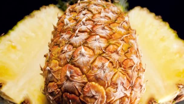 Siyah arkaplanda dilimlenmiş ananasın 4k 'lık yakın çekim videosu. Organik yiyecekler ve sağlıklı beslenme için mükemmel bir soyut çekim. Tropikal meyvelerin kapanışı — Stok video