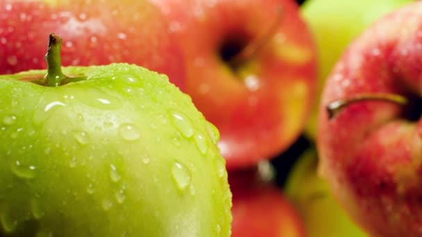 Macro 4k vídeo de la cámara que se mueve entre fresco maduro verde manzanas nad rojo cubierto con gotas de agua o rocío. Perfecto tiro abstracto para alimentos orgánicos y una nutrición saludable. Primer plano de los frutos — Vídeos de Stock