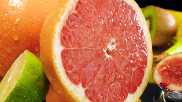 Närbild slow motion video av vattendroppar faller och rulla av klippt grapefrukt. Perfekt abstrakt bild för ekologisk mat och hälsosam kost. Närbild av citrusfrukter — Stockvideo