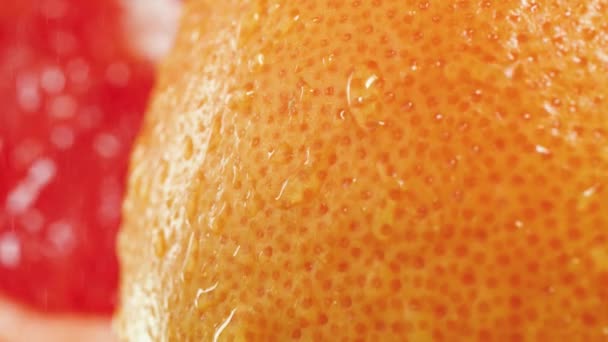 Macro slow motion video of water droplets rolling and falling from grapefruit slin. Perfect abstract shot for organic food and healthy nutrition. Closeup of citrus fruits — Stock Video