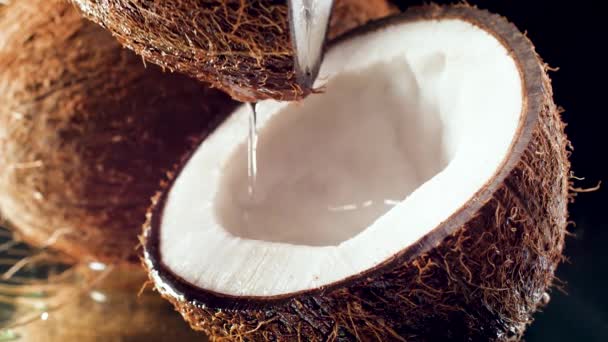 Primer plano video mtoion lento de verter agua o leche en la mitad de coco — Vídeo de stock