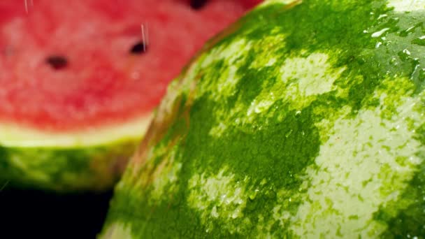 Slow motion video of water drops slowly falling and rolling of green ripe skin of watermelon. Perfect abstract shot for organic food and healthy nutrition. Closeup of tropical fruits — Stock Video