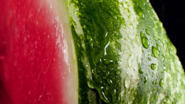 Detailní zpomalení videa tekoucí a padající vody kapky na čerstvé zralé meloun. Perfektní abstraktní snímek pro organické potraviny a zdravou výživu. Detailní záběr ovoce