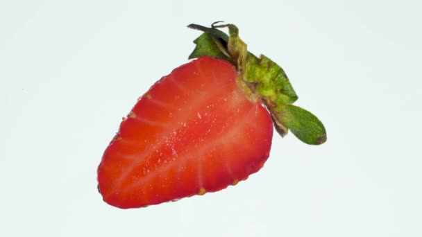 Closeup 4k video of cut ripe strawberry being squeezed and crushed on white background. 有机食品和健康营养的完美的抽象背景。 浆果的包扎 — 图库视频影像