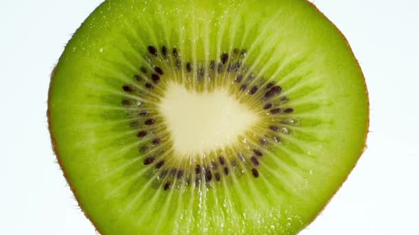 4k video of slice of kiwi fruit squeezing and exploding on white background. Perfect abstract backdrop for organic food and healthy nutrition. — Stock Video