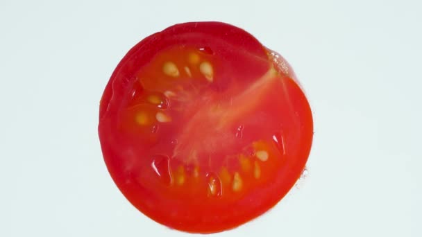 Macro 4k video de compresión y explosión de la pieza de tomate. Elaboración de zumo de tomate o salsa. Fondo abstracto perfecto para alimentos orgánicos y una nutrición saludable . — Vídeo de stock