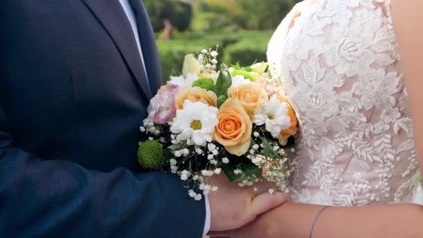 4k Zeitlupe Video der Kamera zoomt aus glücklichen frisch verheirateten Braut und Bräutigam küssen sich im Garten mit Buschzaun — Stockvideo