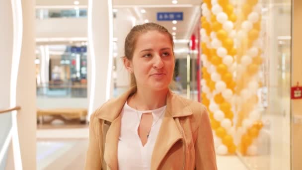 4k video di giovane donna sorridente che cammina in un moderno centro commerciale e guarda in macchina fotografica — Video Stock