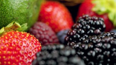 Kamera kamerasının 4k yakın çekim videosu bir sürü ahududu, çilek, böğürtlen ve yaban mersini üzerinden geçiyor. Sağlıklı beslenme ve organik gıdalar için mükemmel bir geçmiş.