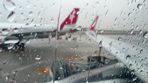 Nahaufnahme 4k Video von Regenwassertropfen, die während des Regens am Flughafen durch das Fenster fließen — Stockvideo