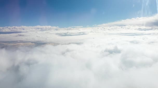 4k video genom flygplansfönstret på vackra moln och ljus sol i blå himmel — Stockvideo