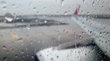 4k video of airplane wing and engine driving on airport runway during strong rain