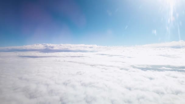 Ver a través del ojo de buey en el avión volando por encima de las nubes en el cielo azul claro — Vídeos de Stock