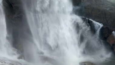 İzlanda 'da kayaların üzerinde kırılan güzel şelalenin 4k' lık videosu.