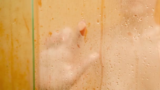 Closeup 4k vídeo de dedo feminino desenhando forma de coração em vidro enevoado no chuveiro enquanto toma abth — Vídeo de Stock