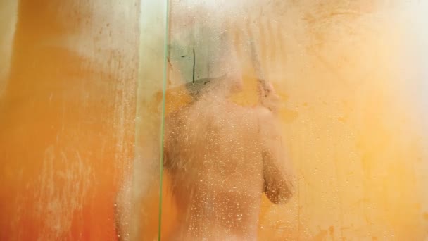 4k video of sexy naked woman enjoying having shower behind misted glass door — Stockvideo