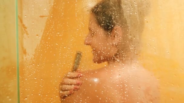 4k-Video durch nasses Glas auf junge sexy Frau beim Waschen in hsower — Stockvideo