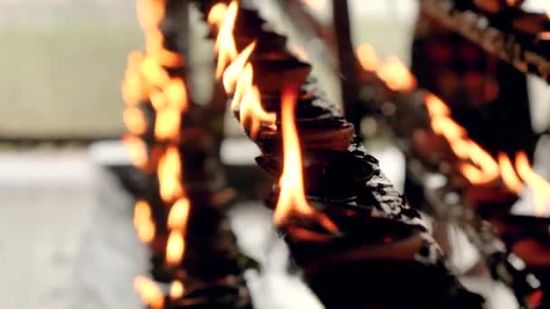 Gros plan vidéo 4k du feu brûlant dans les lampes à huile au sanctuaire du temple — Video