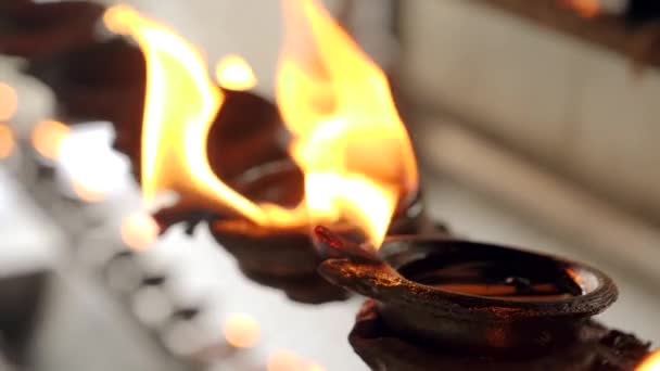 Closeup 4k vídeo of sacred flame burning in oil lamps and candles at asian buddhist temple — Vídeo de Stock