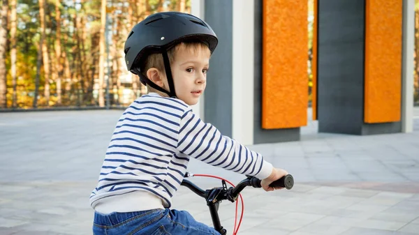 Portrait de petit garçon tout-petit weraing casque de protection chevauchant son vélo — Photo