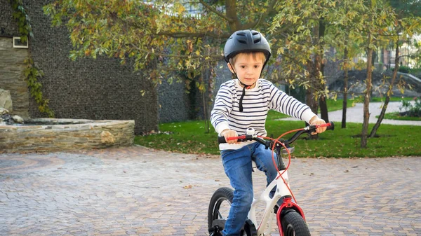 Adorable tout-petit garçon en casque de sécurité vélo d'équitation pour la première fois — Photo